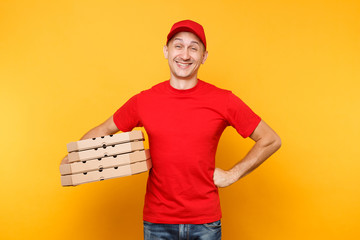 Delivery man in red cap, t-shirt giving food order pizza boxes isolated on yellow background. Male employee pizzaman or courier in uniform holding italian pizza in cardboard flatbox. Service concept.
