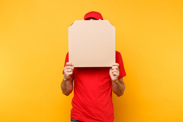 Delivery man in red cap, t-shirt giving food order pizza boxes isolated on yellow background. Male...