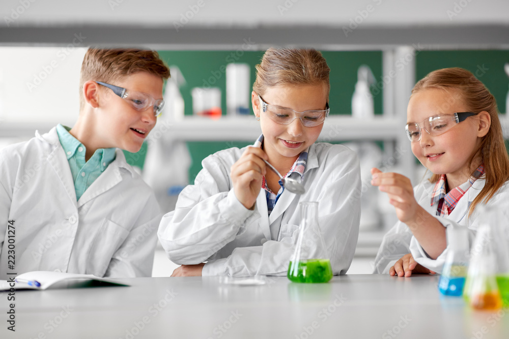 Wall mural education, science, chemistry and children concept - kids or students with test tube making experiment at school laboratory