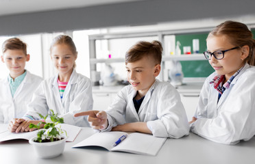 Obraz premium education, science and school concept - kids or students with plant at biology class