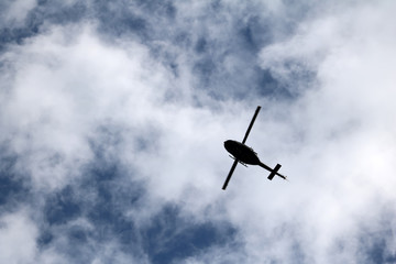 black helicopter aircraft during the flight with blue sky