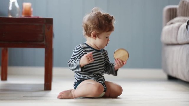 footage of Litle baby play with piece of wood on a floor