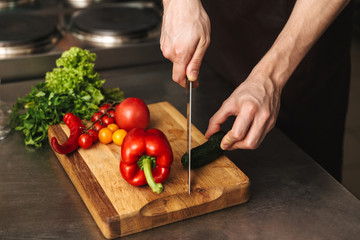 Close up of a man chef hands chopping vegetables