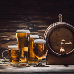 fresh beer in glasses and beer barrel on wooden table, oktoberfest concept