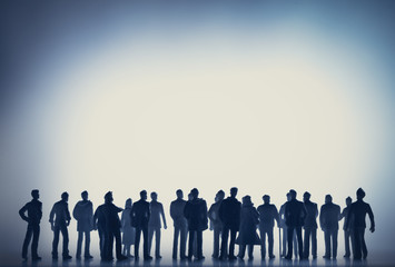 Group of people walking towards the white light.