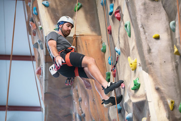 Man climber on artificial climbing wall