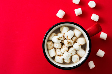 Christmas cocoa with marshmallow in mug on red background. Top view. Copyspace