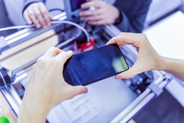 Good work. Two professionals standing around big gadget while doing technological experiment