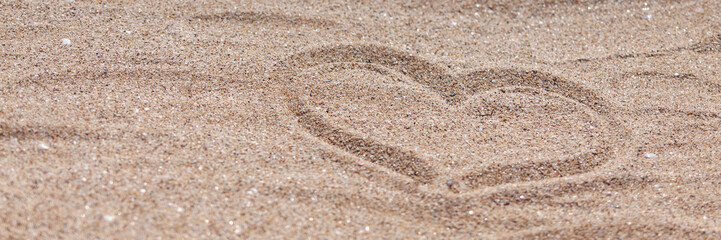 Fototapeta na wymiar Panoramic photo of a sandy beach with a drawn heart