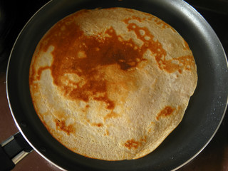 Beautiful pattern of freshly prepared pancake in a frying pan