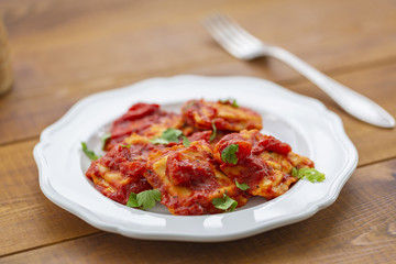 Ravioli with tomato sauce on a white plate