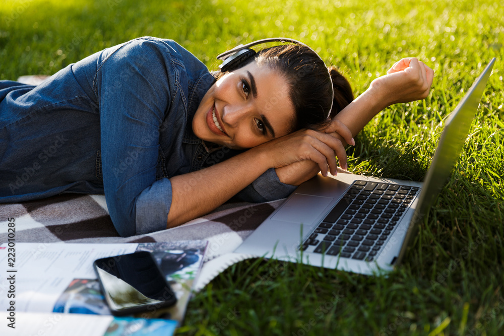 Poster beautiful young woman student in the park using laptop computer.