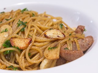 close up Italian cuisine, Spicy spaghetti with pork sausage and garlic in white bowl