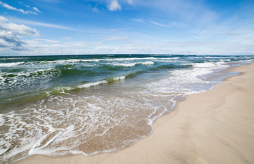 Sand beach and sea waves, Baltic sea seashore during sunset. Curonian spit, Kaliningrad region, Russia