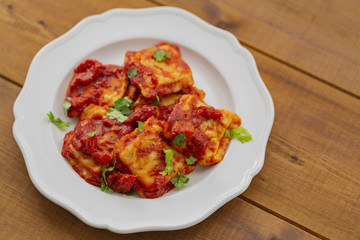 Ravioli with tomato sauce on a white plate