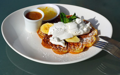 Vegan waffles with fresh banana and coconut cream for breakfast