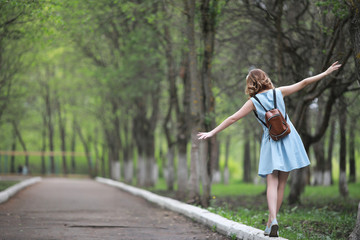 Girl in blue dress in green park