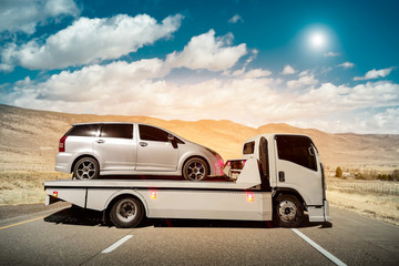 Tow truck delivers the damaged vehicle, Sun light flare, Selective focus