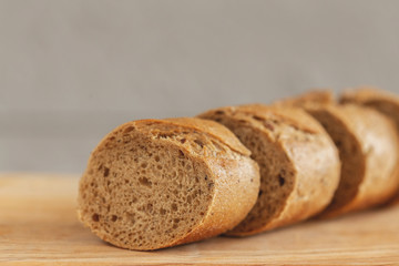 Fresh sliced rye baguette on the wooden cutting board