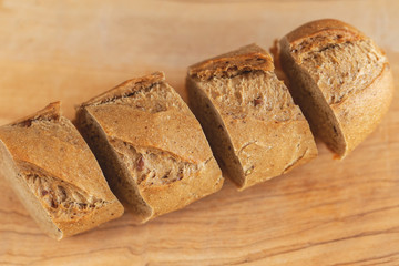 Fresh sliced rye baguette on the wooden cutting board