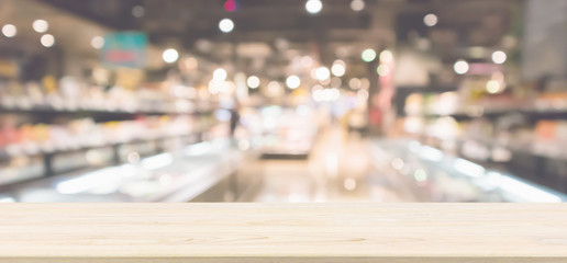Wood table top with Abstract supermarket grocery store refrigerator blurred defocused background with bokeh light