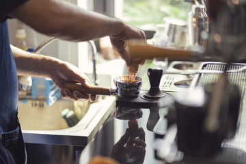 ฺBarista make coffee latte art with coffee machine in coffee shop cafe in vintage color tone