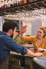 Friendly gesture. Cheerful emotional young girl smiling and greeting the barman with high five