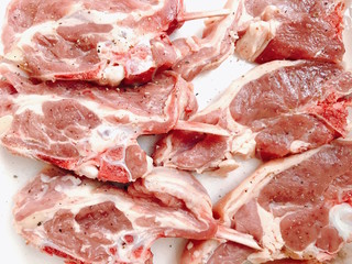 Fresh and raw lamb chops seasoned with salt and pepper