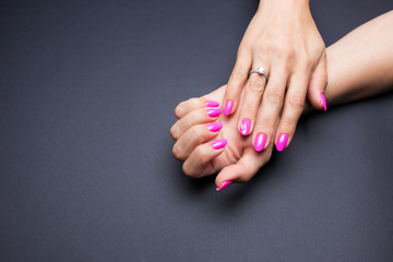 Stylish manicure pink on a black background