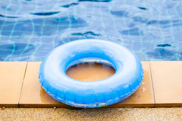 Fototapeta na wymiar Kids life ring on the swimming pool edge close up.