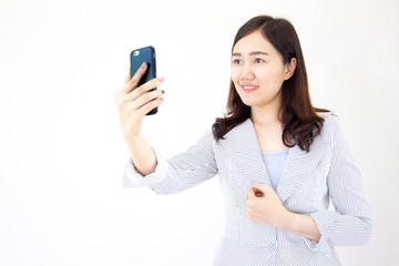 Black hair Asian women take a selfy photo from a smartphone close up on white background.