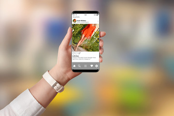 Girl looking at publicly shared photo on social network on her smartphone. Girl promoting red sexy dress on social media app.