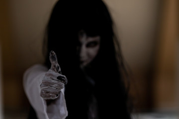 Asian women monster showing the trump up sign close up with copy space on right side.