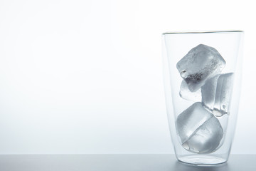 Cubes of ice in the double glass close up on white background.