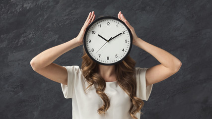Woman holding clock instead of head