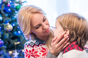 beautiful young mother looking at adorable little son at christmas time