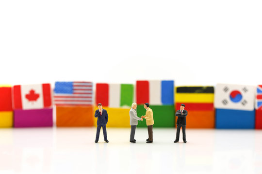 Miniature people : Businessman with international flag using for concept of United Nations Day.