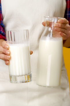 Closeup on young woman farmer showing homemade fresh raw milk