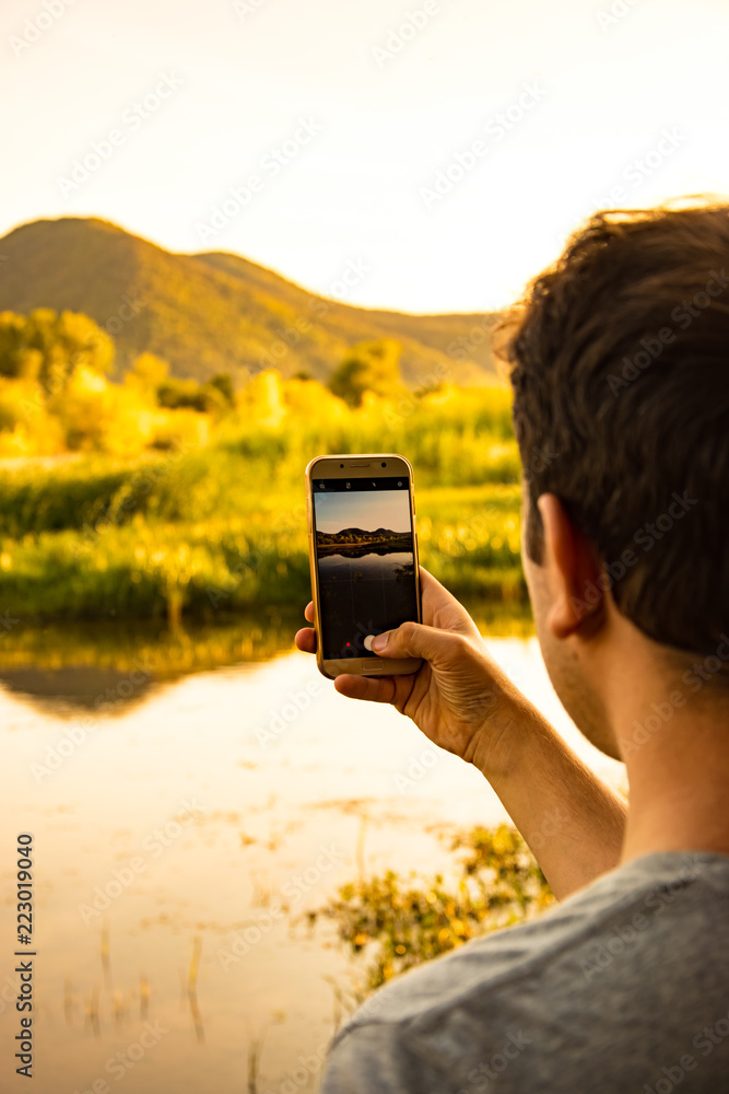 Wall mural make a photo of landscape by mobile phone