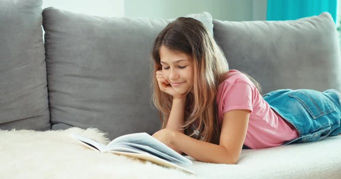 Teen girl lying on sofa with note book