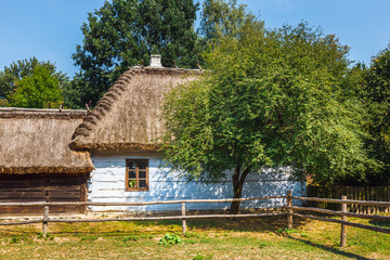 Old log house with thatched roof, traditional rural architecture in Poland