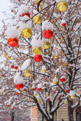 Christmas balls on tree covered with snow. Streets of Moscow decorated for New Year and Christmas celebration. Russia