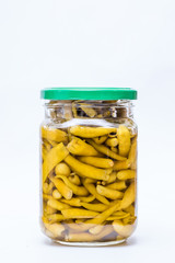 Pickled green chili pepper in a glass jar isolated on white background