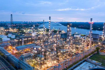 Fototapeta na wymiar Industrial view at oil refinery plant form industry zone with sunrise and cloudy sky.Oil refinery and Petrochemical plant at dusk,Thailand. Aerial view