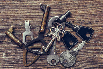 Old antique key and a set of vintage keys on a wooden background a flat top view, a concept of choice