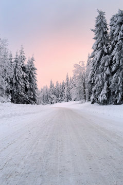 A slippery and dangerous mountain snowy road at dawn.