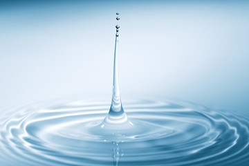 Water drop falling into water making a perfect droplet splash