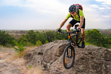 Fototapeta na wymiar Cyclist Riding the Bike on Autumn Rocky Trail at Sunset. Extreme Sport and Enduro Biking Concept.