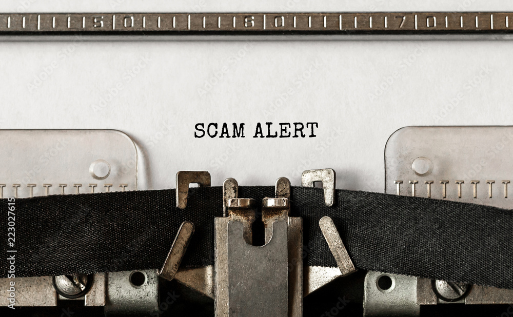 Poster text scam alert typed on retro typewriter