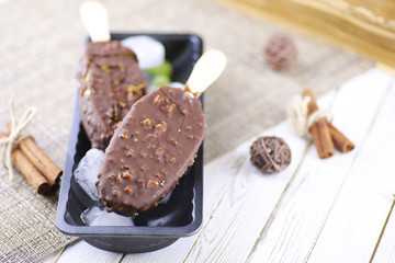 Dessert chocolate ice cream with nuts on wooden stick